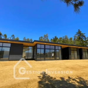 Una casa de diseño contemporáneo recién construida, que destaca por sus muros de vidrio para integrarse con el paisaje, una propiedad exclusiva de Gestión inversión.