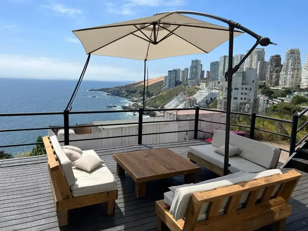 Amplia terraza de madera con living exterior y una vista panorámica al mar y a la costa de Viña del Mar, una propiedad exclusiva de Gestión inversión.