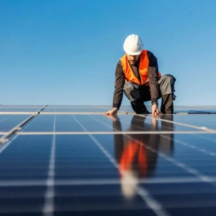 Dos técnicos expertos de Gestión inversión colaborando para instalar un panel fotovoltaico, demostrando el profesionalismo y trabajo en equipo del servicio.