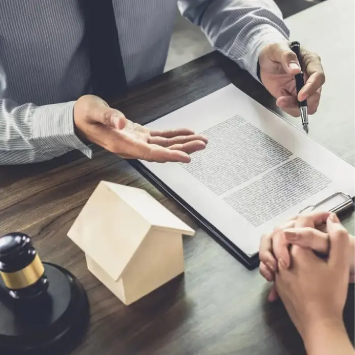 Un abogado de Gestión inversión guiando a un cliente a través de la documentación legal de una propiedad, asegurando la total comprensión de la inversión.