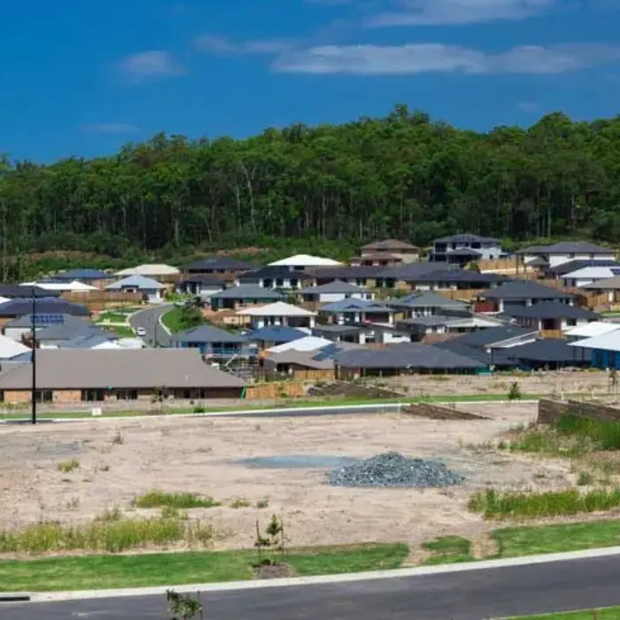 Vista de un desarrollo inmobiliario con un sitio eriazo en primer plano, cuyo valor comercial es tasado por el equipo de Gestión inversión.