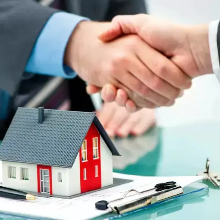 Cierre de un exitoso negocio inmobiliario con un apretón de manos, representando la confianza y asesoría experta de Gestión inversión.