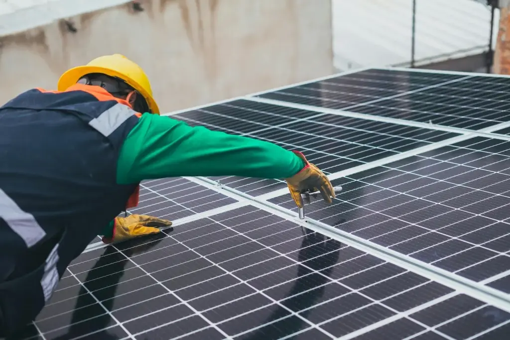 Un instalador profesional de Gestión inversión asegurando con una herramienta la correcta fijación de los paneles solares para garantizar su durabilidad.