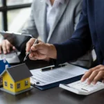 Profesionales revisando documentos y calculando costos relacionados con la compra o regularización de propiedades inmobiliarias