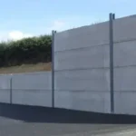 Gran muro de contención de hormigón y acero que nivela un terreno para un proyecto industrial, una obra de ingeniería gestionada por Gestión inversión.